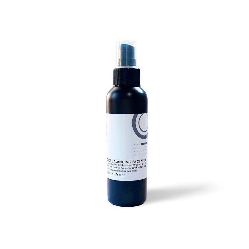 A dark-colored spray bottle with a label reading "Cica Balancing Face Spritz" by Modest Beauty. The bottle features a minimalist design with a fine mist spray nozzle. Enriched with skin-soothing ingredients like willow bark, it contains 3.4 fl. oz (100 ml) of product and is set against a plain white background.
